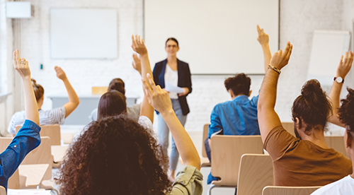 Students raising their hands in a classroom