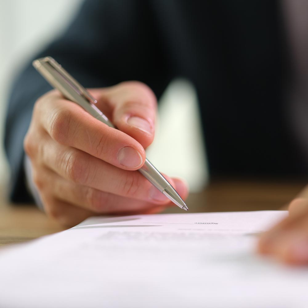 Person som skriver under ett dokument