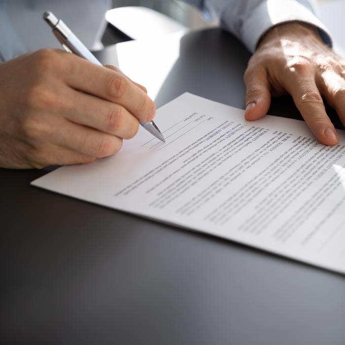 Man som skriver under ett dokument