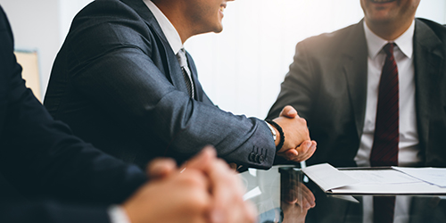 Two men in suit shaking hands