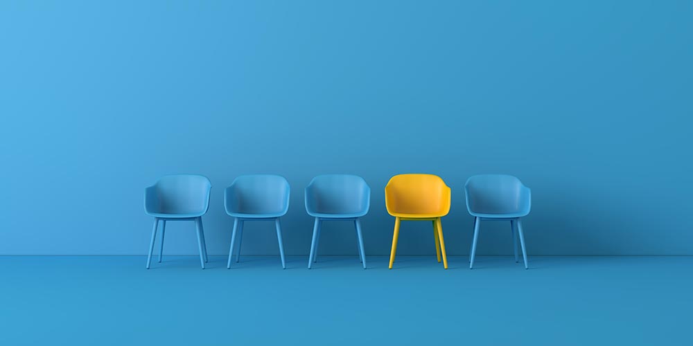Bild på fyra blåa stolar och en gul mot en blå bakgrund